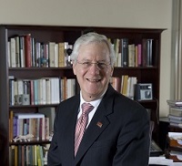 John Schwaller in front of a bookshelf