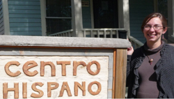Lydia Leon in front of a sign reading "centro hispano"