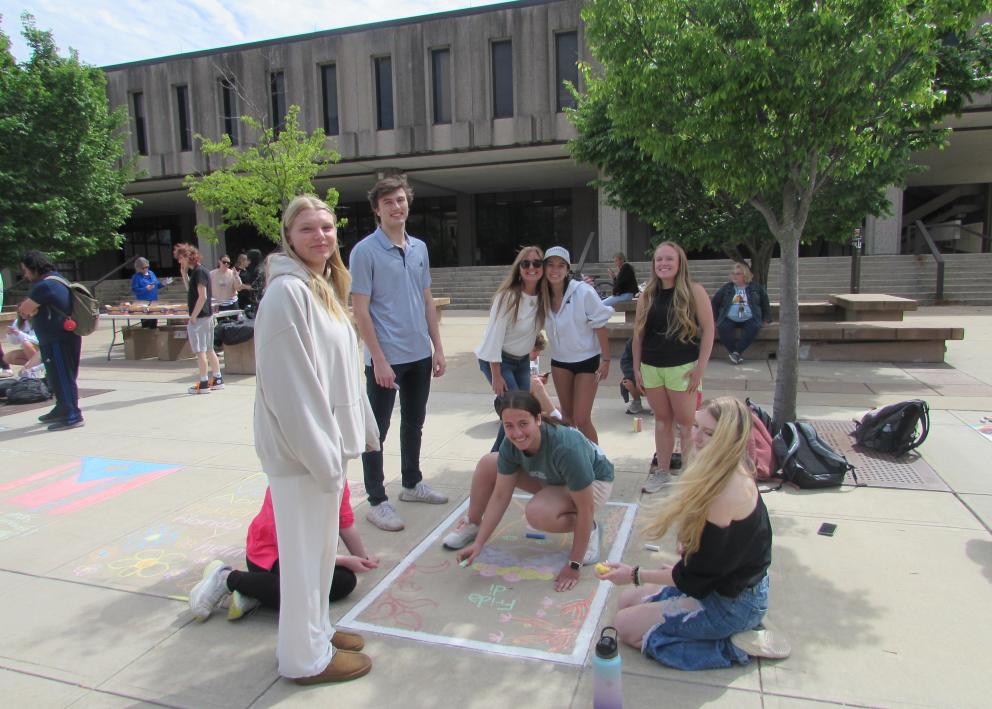 Course Coordinator Etty del Valle with students and chalk art