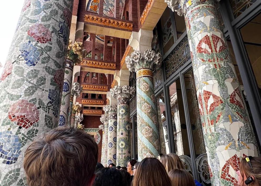 Students outside the Palau de la Música Catalana, looking at colorful mosaic tiled pillars