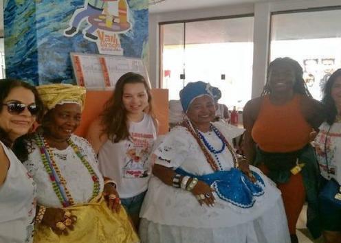Students in Brazil pose with a woman in traditional Brazilian clothing.