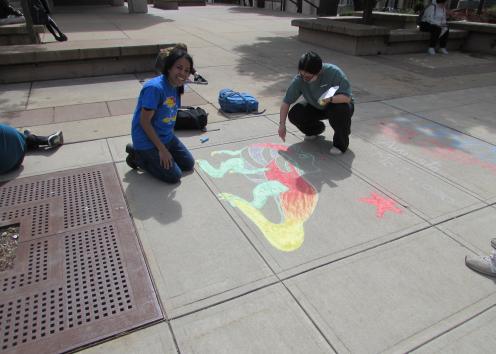 Students drawing chalk art on Wescoe Beach