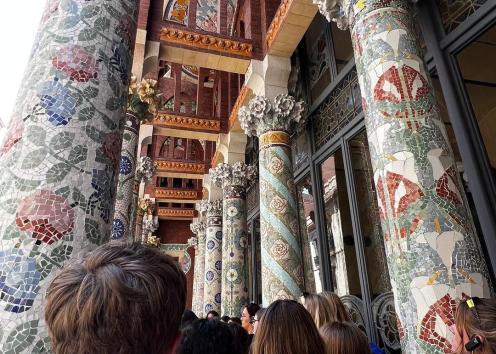 Students outside the Palau de la Música Catalana, looking at colorful mosaic tiled pillars